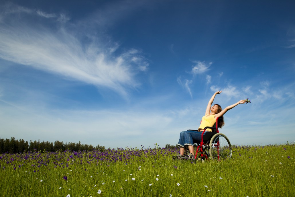 Eine Frau im Rollstuhl auf einer Blumenwiese